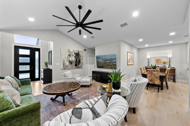 living room featuring high vaulted ceiling and light hardwood / wood-style flooring