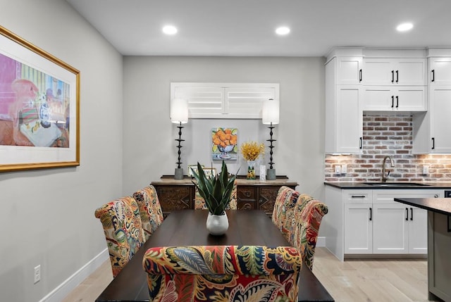 dining room featuring sink and light hardwood / wood-style flooring