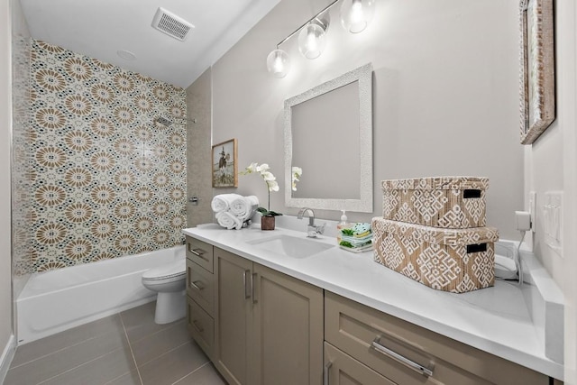 full bathroom with tile patterned flooring, vanity, tiled shower / bath combo, and toilet