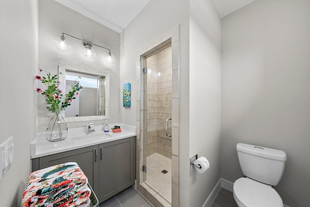 bathroom featuring tile patterned flooring, vanity, a shower with shower door, and toilet