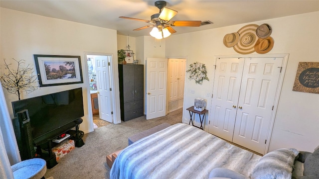 bedroom featuring ensuite bath, light colored carpet, ceiling fan, and a closet