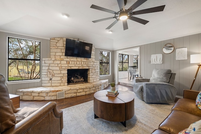 living room featuring hardwood / wood-style flooring, ceiling fan, a wealth of natural light, and a fireplace