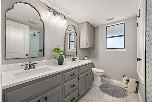 bathroom with tile patterned flooring, vanity, a shower, and toilet