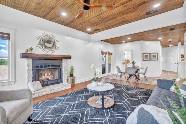 living room with a healthy amount of sunlight, a fireplace, hardwood / wood-style floors, and wooden ceiling