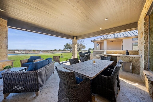 view of patio / terrace with exterior kitchen, ceiling fan, an outdoor hangout area, and grilling area