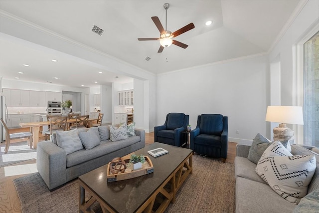 living room with crown molding, wood-type flooring, and ceiling fan