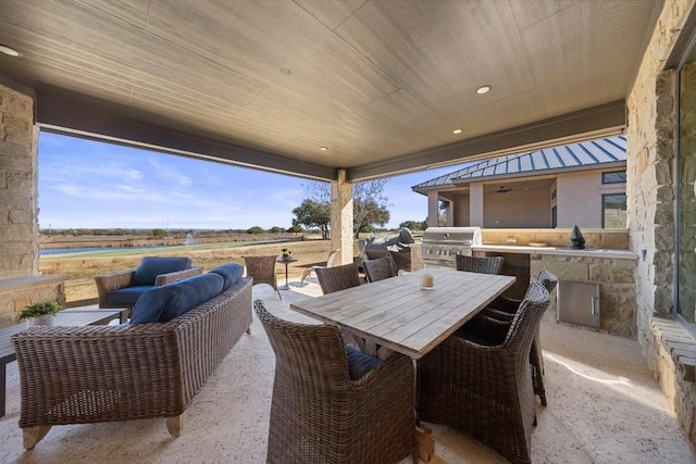 view of patio featuring a rural view, a grill, ceiling fan, and exterior kitchen