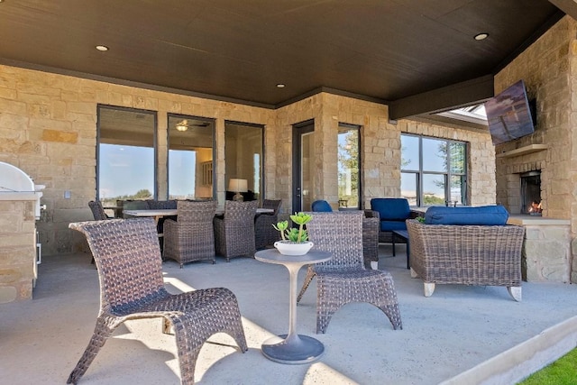 view of patio / terrace with an outdoor living space with a fireplace