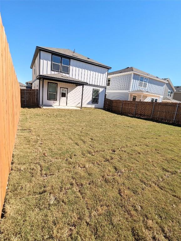 rear view of property featuring a yard