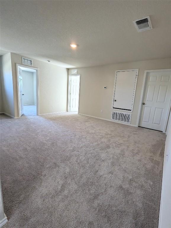 carpeted empty room with a textured ceiling