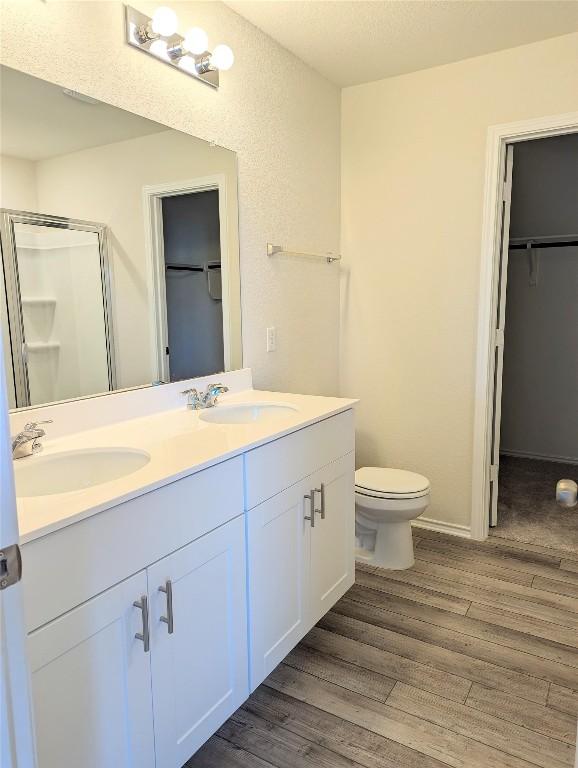 bathroom with vanity, hardwood / wood-style floors, toilet, and walk in shower