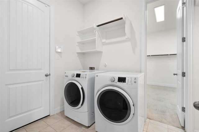 laundry area with washing machine and dryer and light tile patterned floors