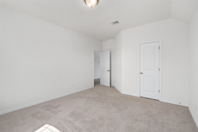 unfurnished bedroom featuring lofted ceiling and light carpet