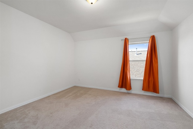 empty room with lofted ceiling and light colored carpet