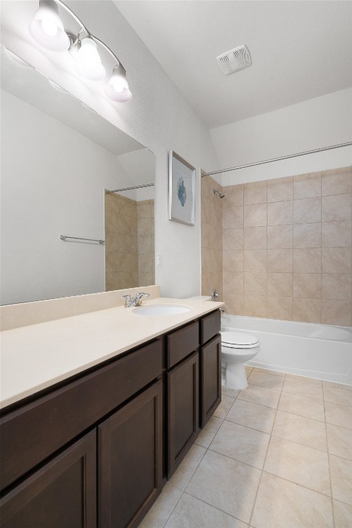 full bathroom with vanity, tiled shower / bath, tile patterned floors, and toilet