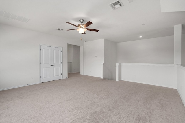 carpeted spare room featuring ceiling fan