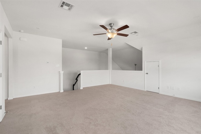 empty room featuring vaulted ceiling, light colored carpet, and ceiling fan