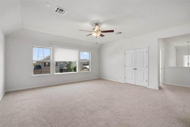 carpeted empty room featuring ceiling fan and vaulted ceiling