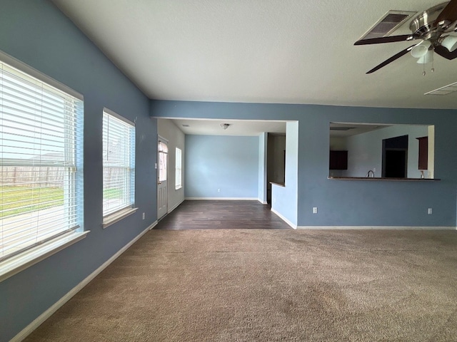 2709 Calypso Pl, Texas City, TX 77568 - unfurnished living room featuring dark colored carpet, baseboards, and ceiling fan