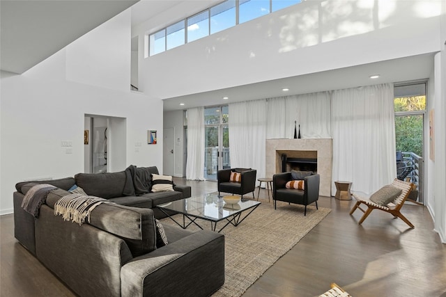 living room featuring dark wood-type flooring and a tiled fireplace