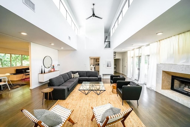 2909 Stratford Dr, Austin, TX 78746 - living area with wood finished floors, ceiling fan, a fireplace, a high ceiling, and recessed lighting