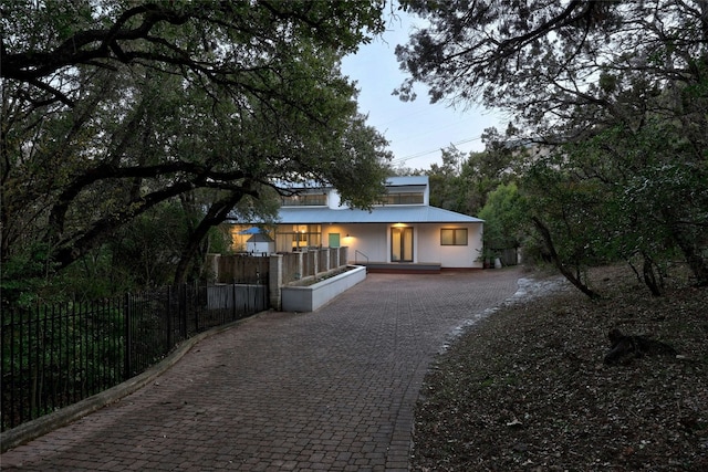 2909 Stratford Dr, Austin, TX 78746 - view of front facade featuring a porch, a fenced front yard, stucco siding, and driveway