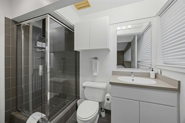 bathroom with a shower with door, vanity, and toilet