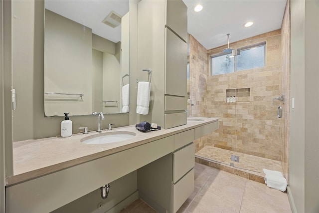 bathroom with a shower with door, vanity, and tile patterned floors