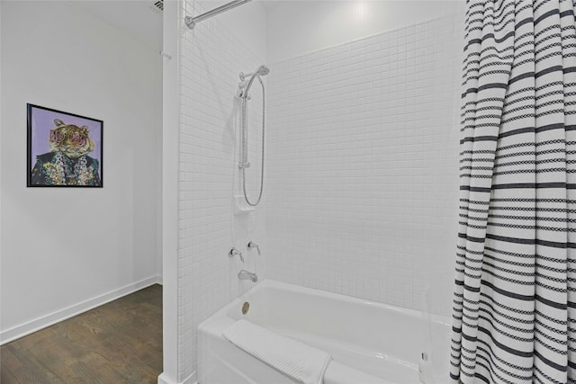 bathroom with hardwood / wood-style flooring and shower / tub combo with curtain