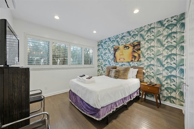 bedroom with dark hardwood / wood-style flooring and a wall unit AC