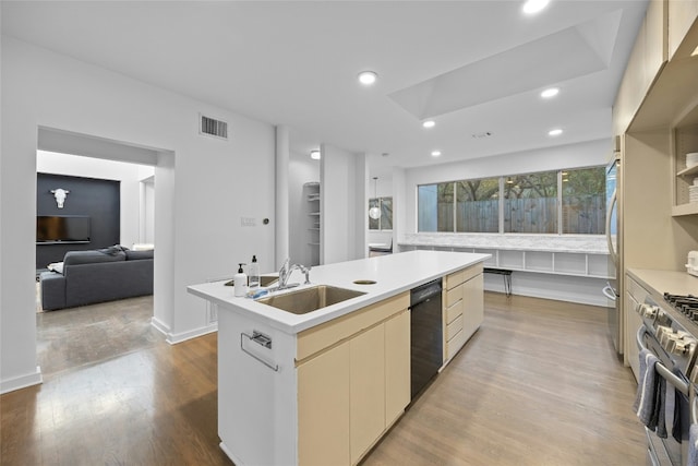 kitchen featuring sink, stainless steel gas stove, light hardwood / wood-style flooring, dishwasher, and an island with sink