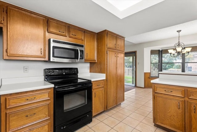 kitchen with light tile patterned flooring, black range with electric stovetop, hanging light fixtures, and a notable chandelier