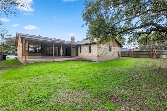 back of property with a lawn and a patio