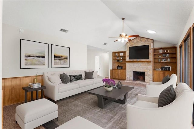 living room with lofted ceiling, built in shelves, a fireplace, and ceiling fan