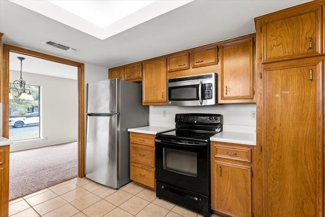 kitchen with pendant lighting, light colored carpet, and appliances with stainless steel finishes