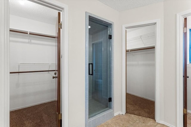 bathroom featuring a shower with door and a textured ceiling