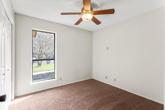 empty room featuring ceiling fan, carpet flooring, and a textured ceiling