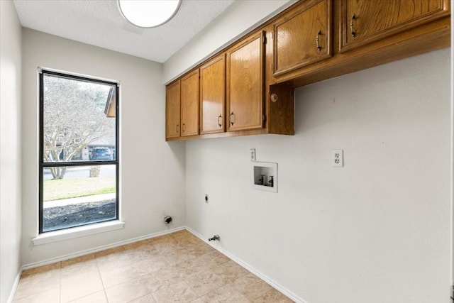 washroom featuring cabinets, hookup for an electric dryer, hookup for a washing machine, and a wealth of natural light