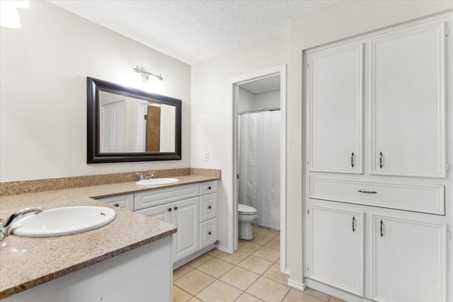 bathroom featuring tile patterned flooring, vanity, toilet, a textured ceiling, and a shower with curtain