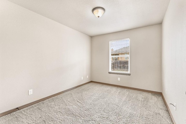 carpeted empty room featuring a textured ceiling