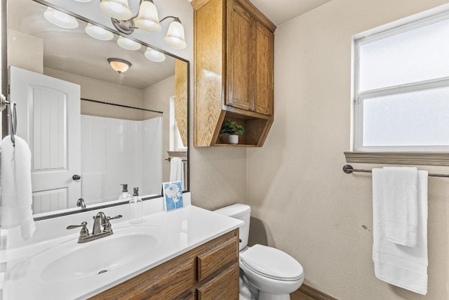 bathroom featuring vanity, a shower, and toilet