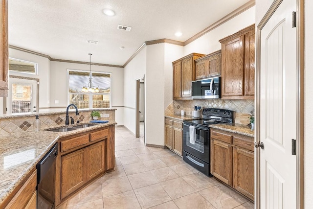 kitchen featuring sink, light stone counters, tasteful backsplash, hanging light fixtures, and black appliances