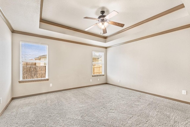 carpeted empty room featuring crown molding, a textured ceiling, a raised ceiling, and ceiling fan