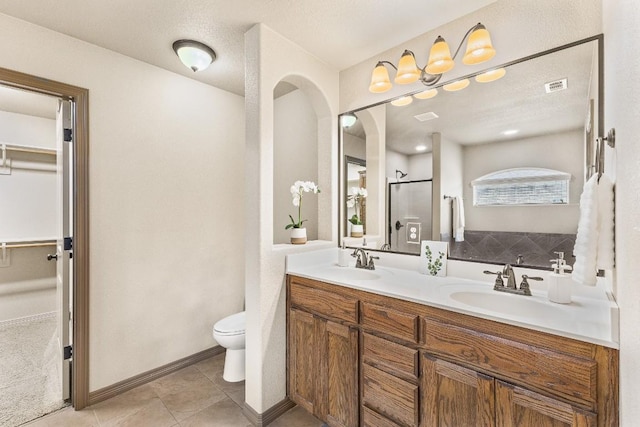 bathroom featuring vanity, tile patterned flooring, a shower with door, and toilet