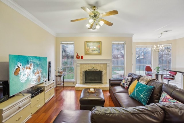 living room with a premium fireplace, ornamental molding, ceiling fan with notable chandelier, and dark hardwood / wood-style flooring