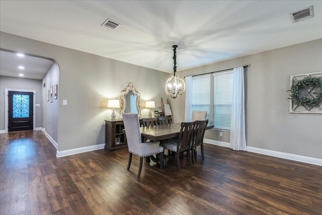 dining area with a notable chandelier and dark wood-type flooring