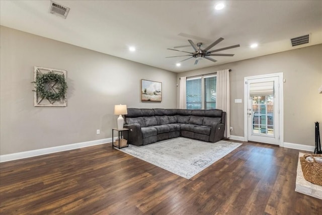 living room featuring ceiling fan and dark hardwood / wood-style floors