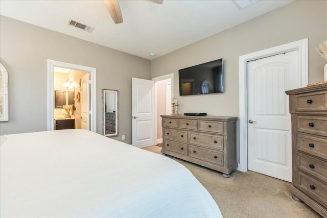 bedroom with ceiling fan, connected bathroom, and light colored carpet