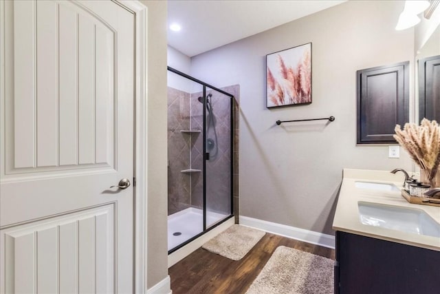 bathroom with wood-type flooring, vanity, and walk in shower