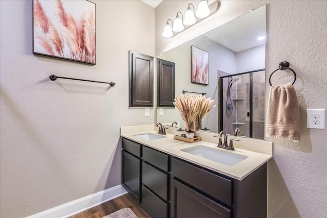 bathroom featuring wood-type flooring, a shower with shower door, and vanity